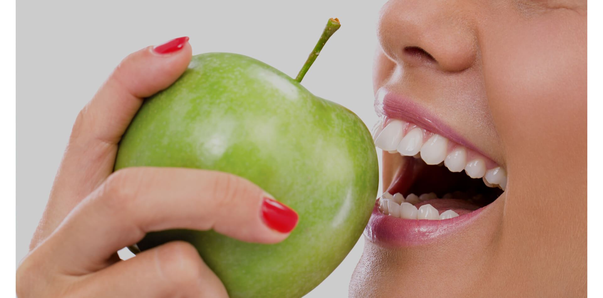 Closeup of the face of a woman eating a green apple